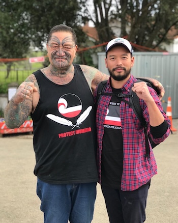 Kalaya’an Mendoza and “Uncle” Jack donning shirts that read “PROTECT IHUMĀTAO” during the Occupation of Ihumātao in Aotearoa/New Zealand (2019).