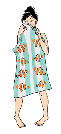 A woman shyly hiding behind a towel.